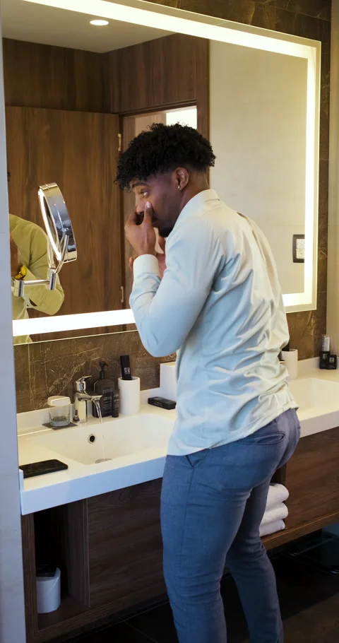 Black businessman getting ready for work while standing in bathroom in fron.. Stock Footage 336187367