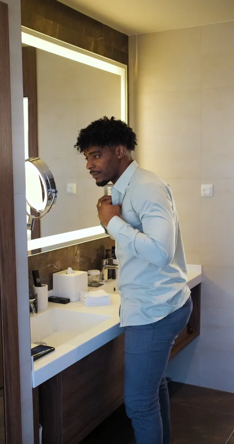 Black businessman getting ready for work while standing in bathroom in fron.. Stock Footage 336187376