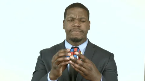 Black businessman trying to solve a cube puzzle (1) Stock Footage 61651853
