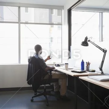 Black Businessman Using Cell Phone In Office