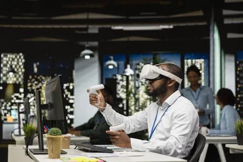 Black businessman using VR headset and gadgets to draft a project plan Stockfoto's
