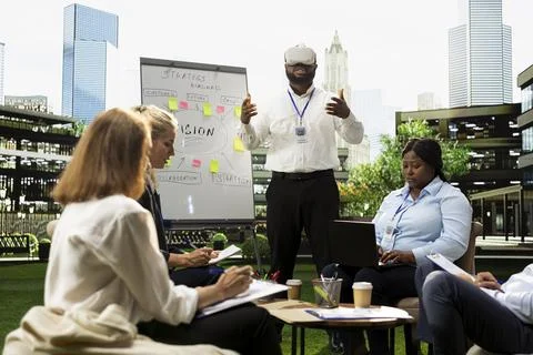 Black businessman with VR glasses explaining roadmap ideas with hands raised Stock Photos