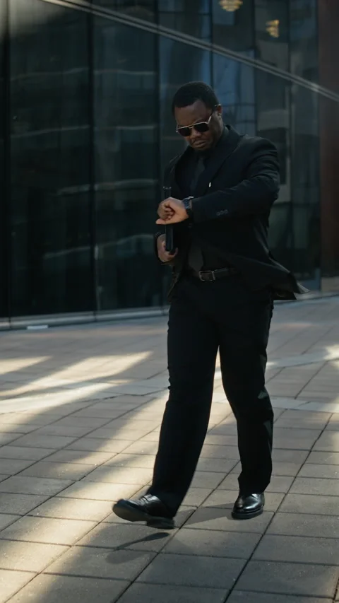Black Businessman Walking Outdoors Checking Time on Watch for Meeting Stock Footage 339410138