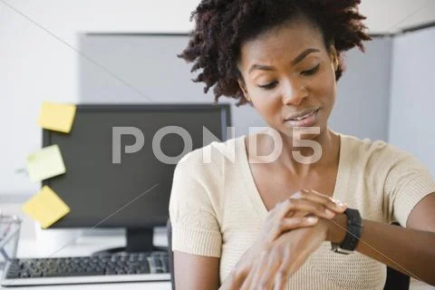 Black Businesswoman Checking The Time At Desk