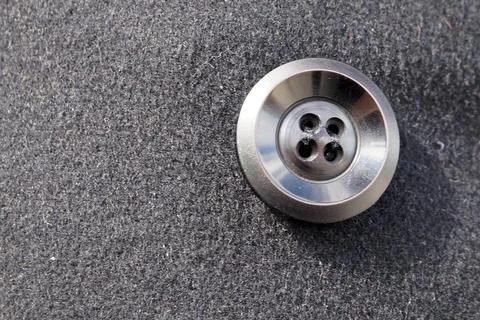 Black button on a black drape coat close-up Stock Photos