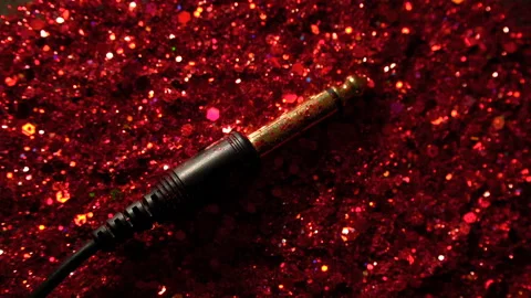 Black cable on the background of red glitter Stock Footage 100012843