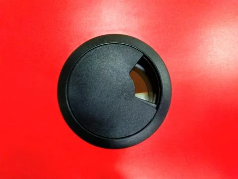 Black Cable Grommet with Red Background, Office Desk Accessory. Stock Photos