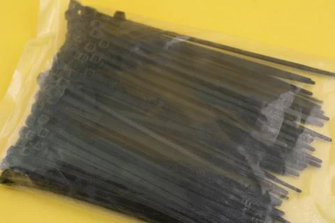 Black cable ties packaged for organizing and securing items in home or offi.. Stock Photos