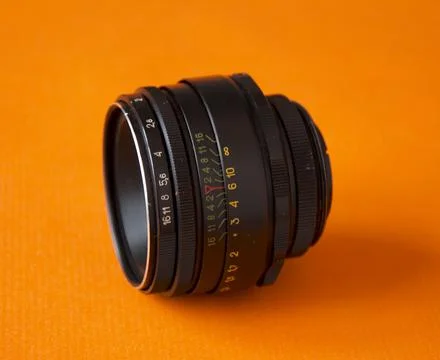 Black camera lens isolated on an orange background. Foto stock