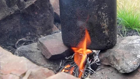 Black camping pot standing in a campfire. Outdoor cooking in the mountains Stock Footage 316484580