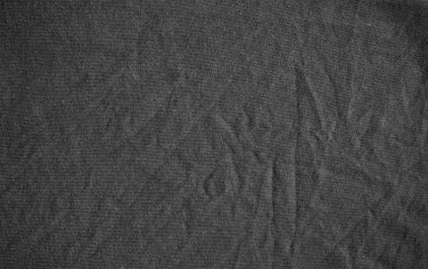 Black canvas with delicate striped pattern, crumpled. Dark fabric texture. Stock Photos