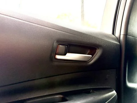 Black car door handle with window control button. Fotos de archivo