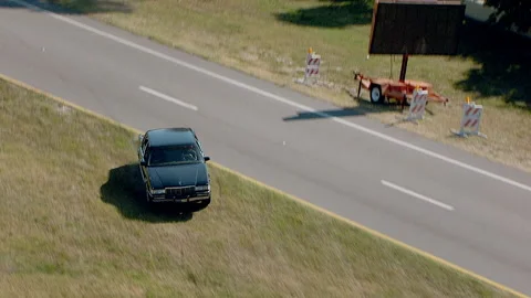 Black car drives erratically across median in car chase 動画素材 136199519