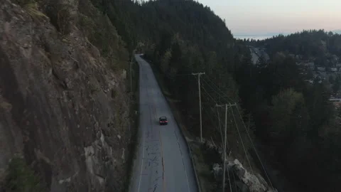 Black car driving on mountain road early evening Stock Footage 154656341