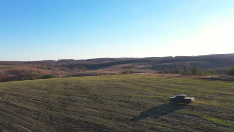 Black car driving through field after harvesting. Pickup truck riding Stock Footage 294325791