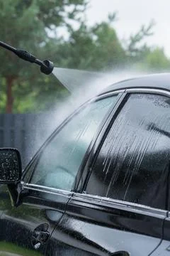 Black car getting a thorough professional wash with a high pressure water s.. Stock Photos