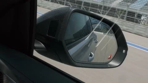 Black car in motion, the road is reflected in the side view mirror, long Vidéo 157526046