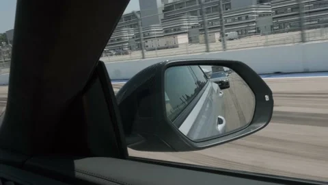 Black car in motion, the road is reflected in the side view mirror, long Vidéo 157526068