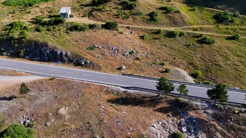 Black car navigating a scenic winding mountain road Stock Footage 285260769