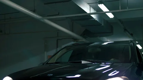 Black car rides through an underground parking lot Stock Footage 102665707