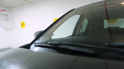 Black car windshield and wipers in an underground parking garage Stock Footage 322176427