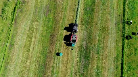 Black case tractor with a red Kuhn Meifort straw fixed chamber press Video stock 133727641