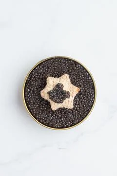 Black caviar and an appetizer starshaped butterbread Stock Photos