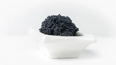 Black caviar in a small dish on isolated white background, close-up rotation. 스톡 동영상 63534854