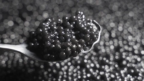 Black caviar in a spoon on a background of a rotating background Stock Footage 123639292