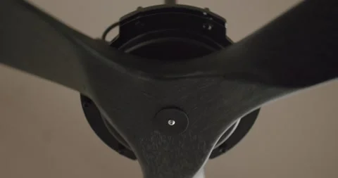 Black ceiling fan propeller spinning slowly Stock Footage 345543120