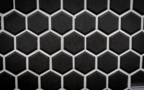 Black ceramic cells on the wall as background Stock Photos