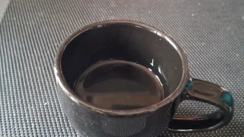 Black ceramic coffee cup sitting on textured surface video footage Video stock 336252132