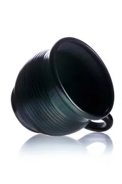 Black ceramic cup lying on its side on white isolated background. Stock Photos