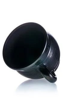Black ceramic cup lying on its side on white isolated background Stock Photos