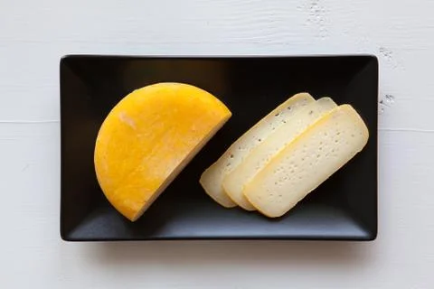 Black ceramic rectangle dishes with block of tasty cheese Stock Photos