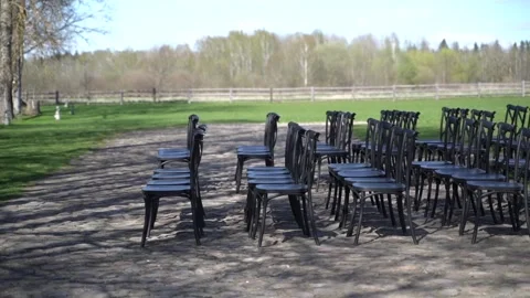 Black chairs stand in rows outside. Preparations for a wedding ceremony. Stock Footage 342993422