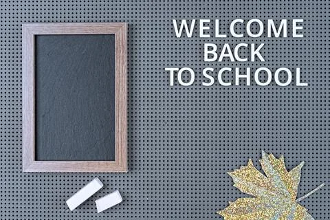Black chalk board in a frame on a gray background with the inscription. Stock Photos