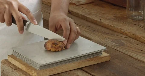 Black chef cut a pastry with a liquid chocolate in Stock Footage 75205473