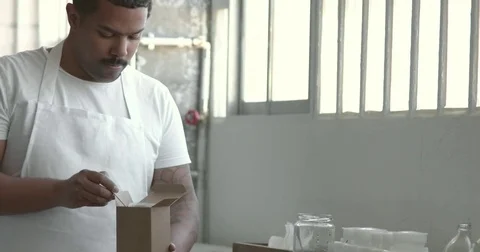 Black chef take some flour from the box Stock Footage 75188600