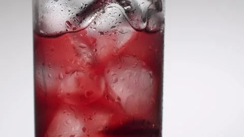 Black cherries dropping into a refreshing cold drink with ice Stock Footage 342743498