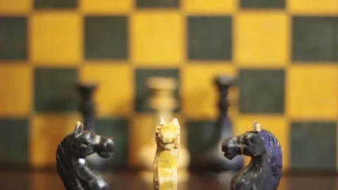 BLACK CHESS KNIGHT ATTACKS AND DESTROYS WHITE CHESS KNIGHT Stock Footage 74884355
