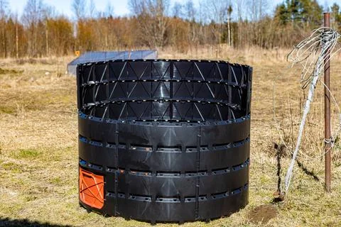 Black circular compost bin with orange door, made of plastic panels, standi.. Stockfoto's