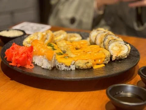 Black Circular Sushi Plate with Assorted Rolls Stock Photos