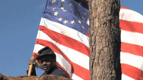Black Civil War Union soldier holds U.S. flag on battlefield Stock Footage