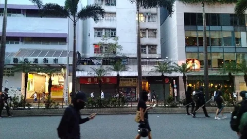 Black clad protesters walking around during protest day in Hong Kong Stock Footage 116184899