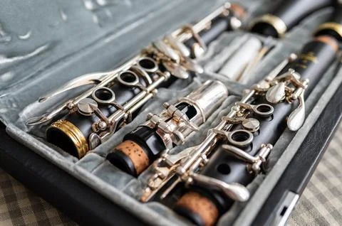 A black clarinet rests in an open case with a plush interior. The selective f Stock Photos