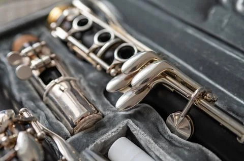 A black clarinet rests in an open case with a plush interior. The selective f Stock Photos