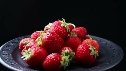 Black clay plate with red appetizing juicy strawberries Stock Footage 156693505