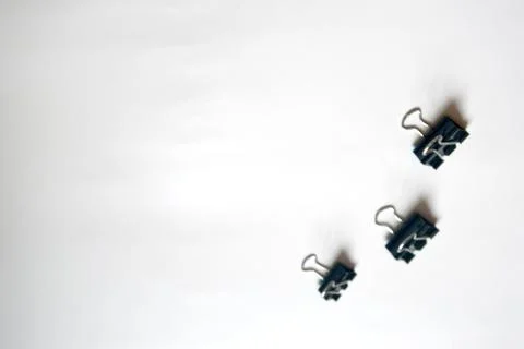 Black clips for documents, binding. Paper clips on a white background. statio Stock Photos
