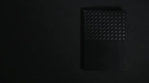 Black closed notebook on dark background Stock Footage 327288504